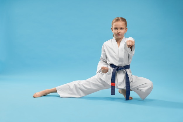 Karate niña de pie en posición y entrenamiento de perforación.