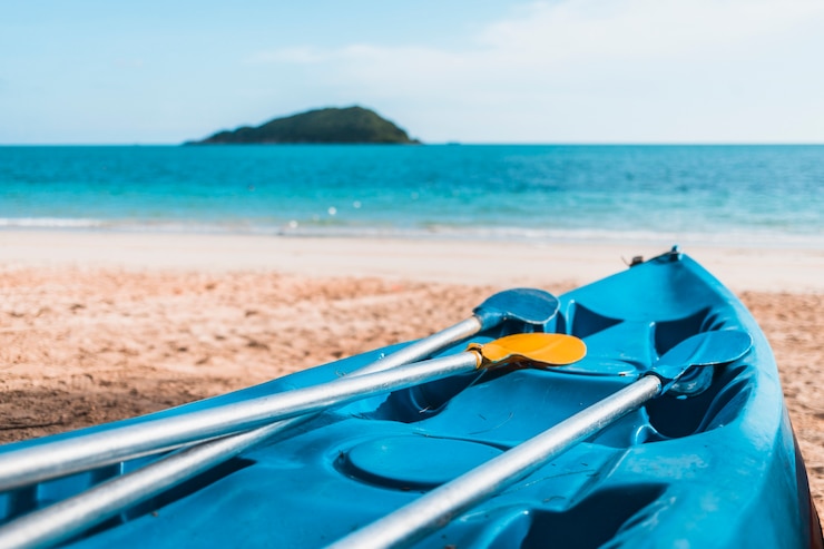 Foto gratuito kayak azul en la orilla del mar de arena
