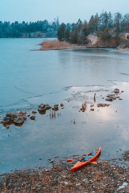 Kayak se encuentra en una playa salvaje de un lago salvaje