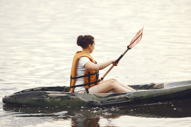 Kayak. Una mujer en kayak. Chica remando en el agua.