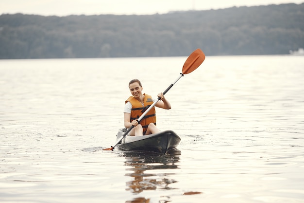 Kayak. Una mujer en kayak. Chica remando en el agua.