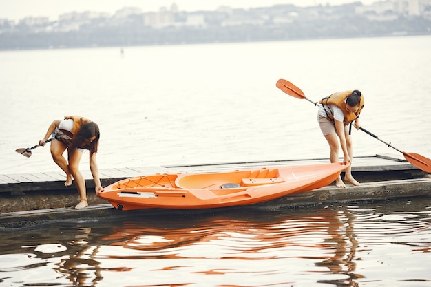 Kayak. Una mujer en kayak. Las niñas se preparan para pasear en un lago.