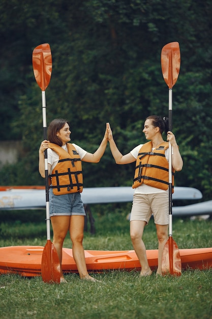 Foto gratuita kayak. una mujer en kayak. las niñas se preparan para pasear en un lago.