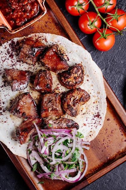 Foto gratuita kebab de carne azerbaiyana en pan lavash con ensalada de cebolla y salsa barbacoa.