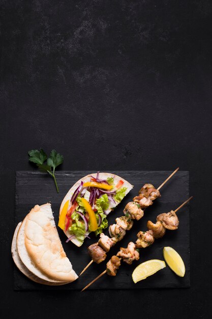 Kebab de carne y verduras cocidas en mesa negra