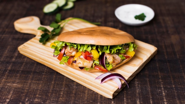 Kebab de carne y verduras cocidas en tabla de cortar