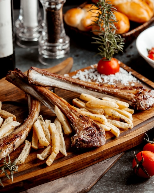 Kebab de costillas de cordero servido con fuego francés sobre tabla de madera