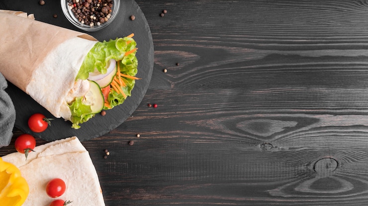 Foto gratuito kebab envuelto con carne y verduras en el plato