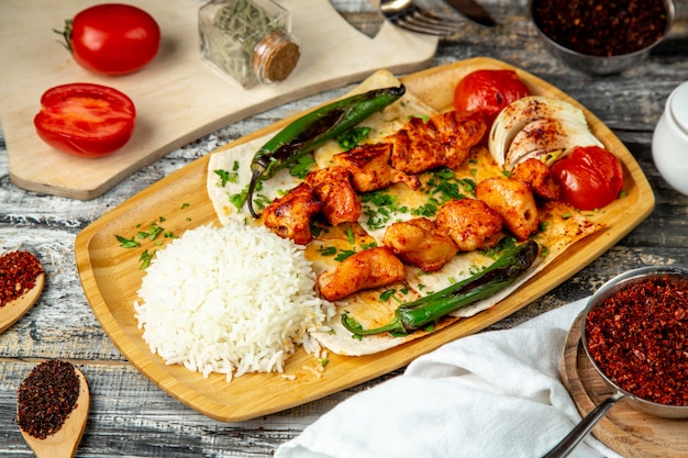 Kebab de pollo con vista lateral de arroz y pimienta