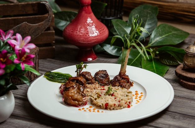 Foto gratuita kebab de ternera con guarnición de arroz y semillas de granada