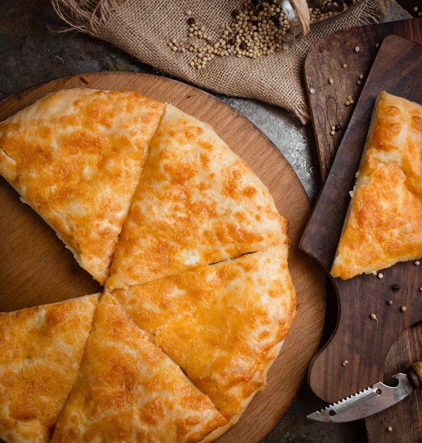 Khachapuri pizza georgiana en rodajas sobre un queso derretido.