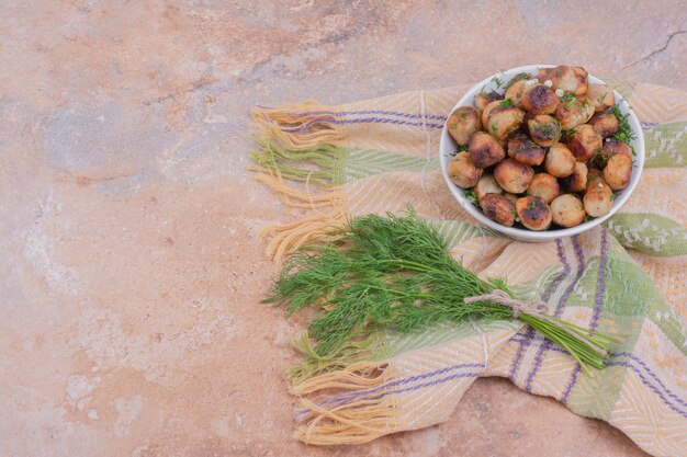 Khinkali caucásico cocido en un plato blanco servido con hierbas y especias.