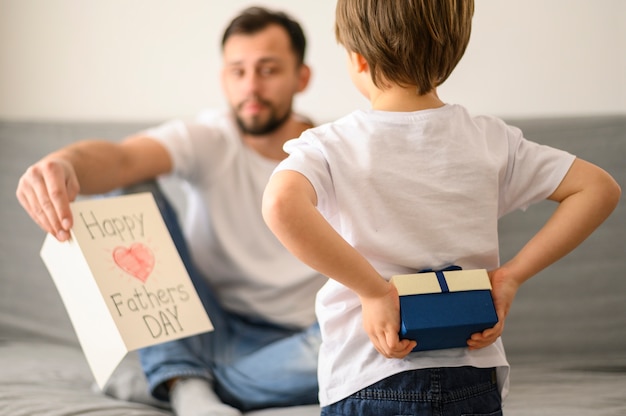 Foto gratuita kid sorprendente papá con regalo