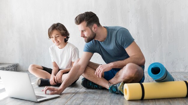 Kid y su padre haciendo deporte en casa