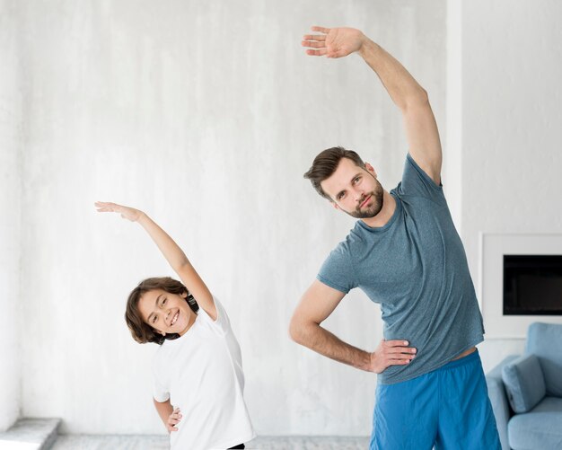 Kid y su padre haciendo deporte en casa