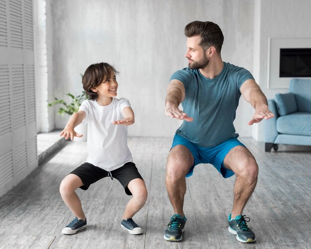 Kid y su padre haciendo deporte en casa