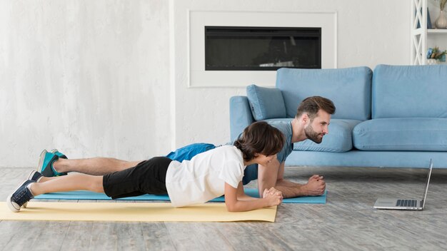 Kid y su padre haciendo deporte en casa