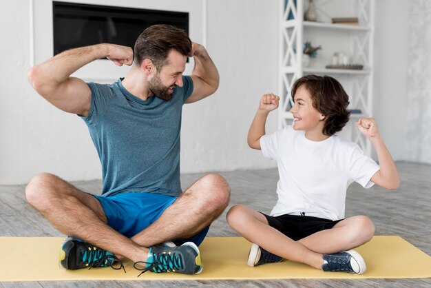 Kid y su padre haciendo deporte en casa