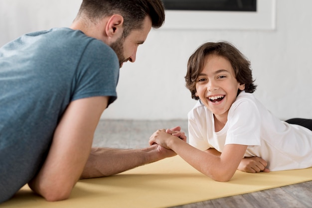 Kid y su padre haciendo deporte en casa