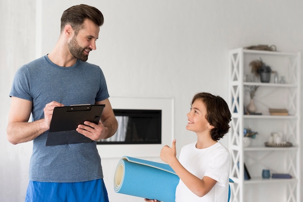 Kid y su padre haciendo deporte en casa