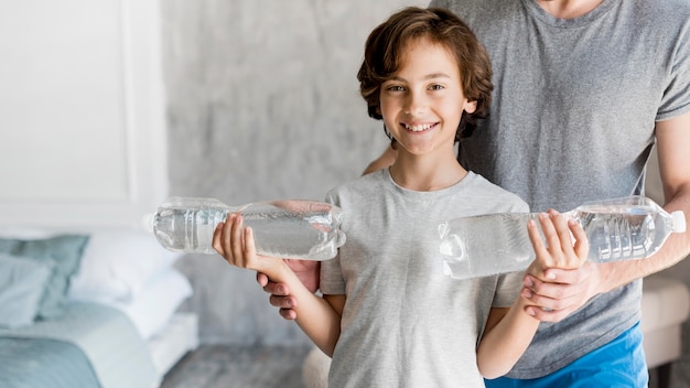 Foto gratuita kid y su padre haciendo deporte en casa