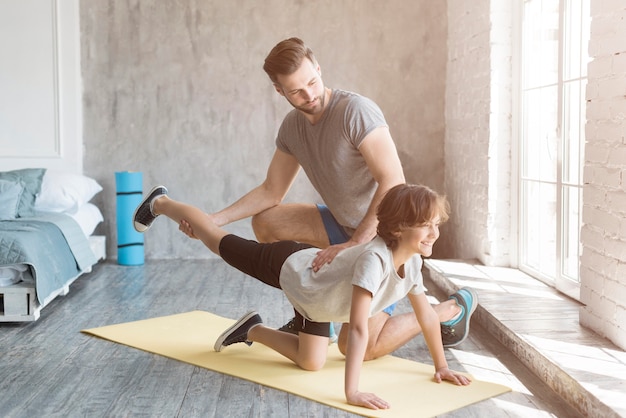 Kid y su padre haciendo deporte en casa