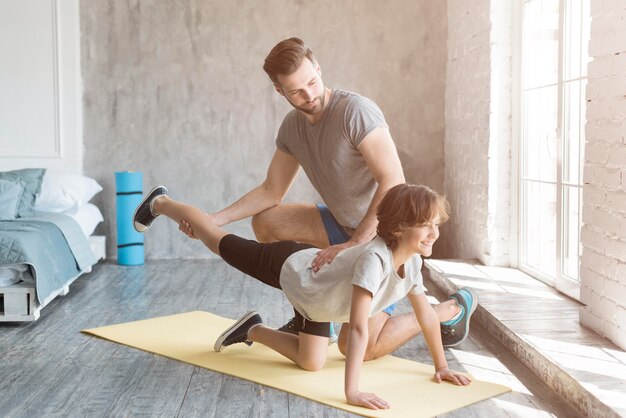 Kid y su padre haciendo deporte en casa