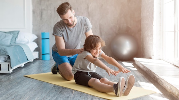 Kid y su padre haciendo deporte en casa