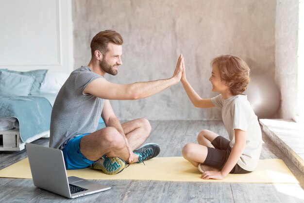 Kid y su padre haciendo deporte en casa