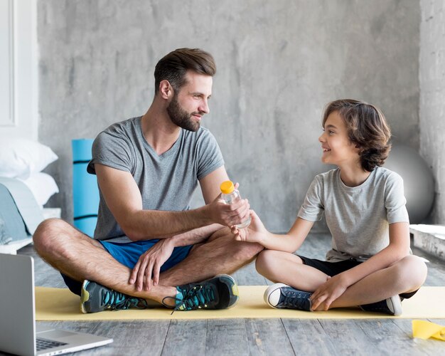 Kid y su padre haciendo deporte en casa