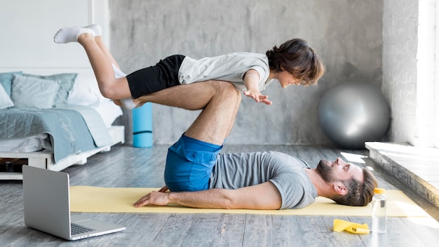 Kid y su padre haciendo deporte en casa