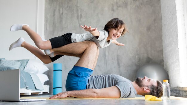 Kid y su padre haciendo deporte en casa