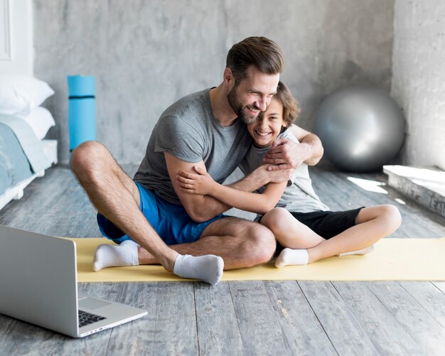 Kid y su padre haciendo deporte en casa