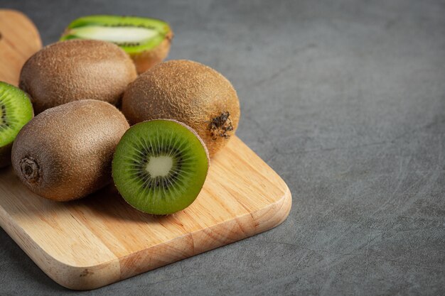 Foto gratuita kiwi fresco, cortado por la mitad, colocado sobre una tabla de cortar de madera