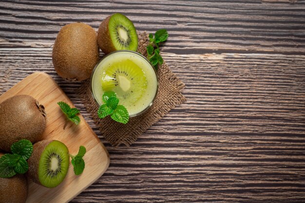 Kiwi fresco, cortado por la mitad, colocado sobre una tabla de cortar de madera