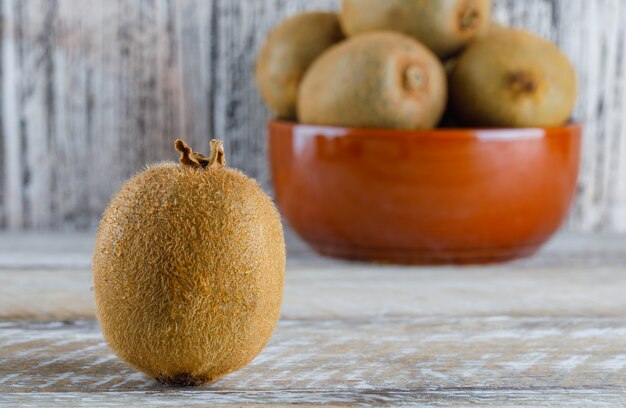 Kiwi fresco en una vista lateral del tazón sobre una mesa de madera