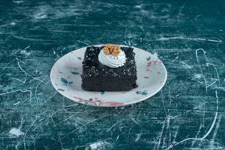 Photo Gratis kue cokelat di atas piring di atas warna biru.