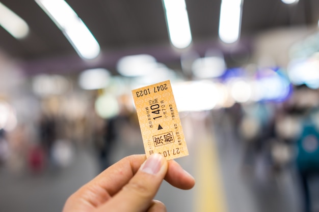 KYOTO, JAPÓN - 1 DE NOVIEMBRE: Boleto ferroviario japonés en la mano indefinida Kyoto del hombre, Japón el 1 de noviembre de 2015.