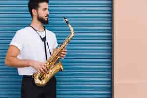 Foto gratuita lado medio músico de tiro posando con saxofón