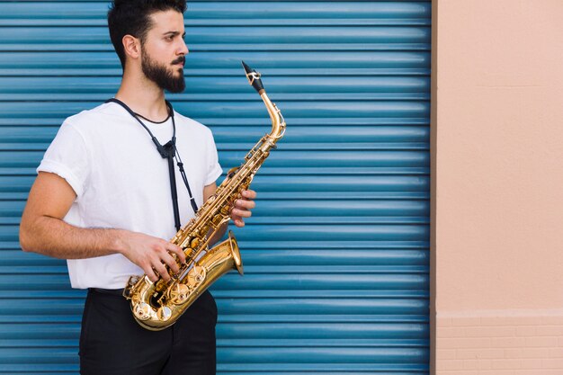 Lado medio músico de tiro posando con saxofón