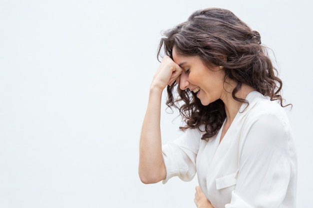 Foto gratuita lado de mujer alegre con los ojos cerrados, inclinando la cabeza en la mano