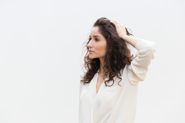 Lado de pensativa seria hermosa mujer tocando el cabello