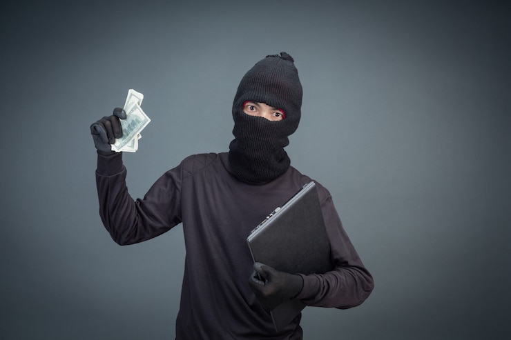 Foto gratuito los ladrones masculinos roban una computadora portátil en gris