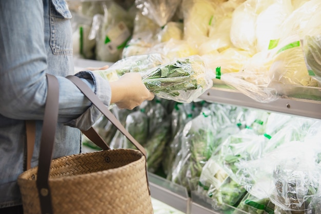 Lady está comprando vegetales frescos en la tienda de supermercado