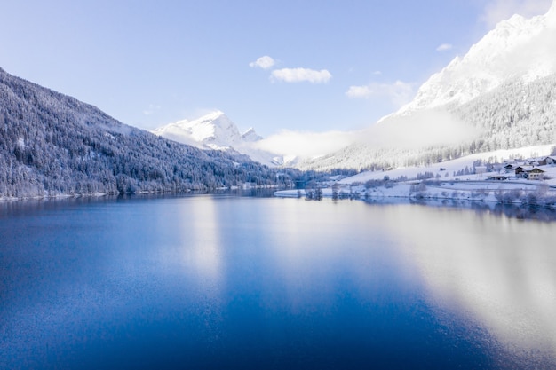 Lago por las colinas cubiertas de nieve capturado en un día soleado