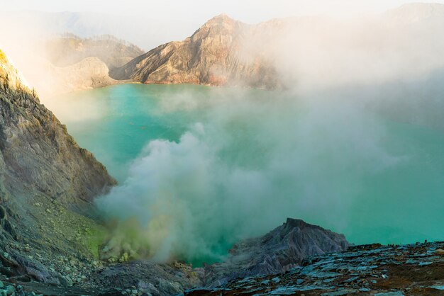 Lago en medio de un paisaje rocoso que expulsa humo