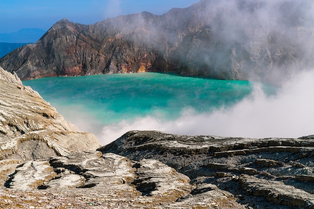 Foto gratuita lago en medio de un paisaje rocoso que expulsa humo