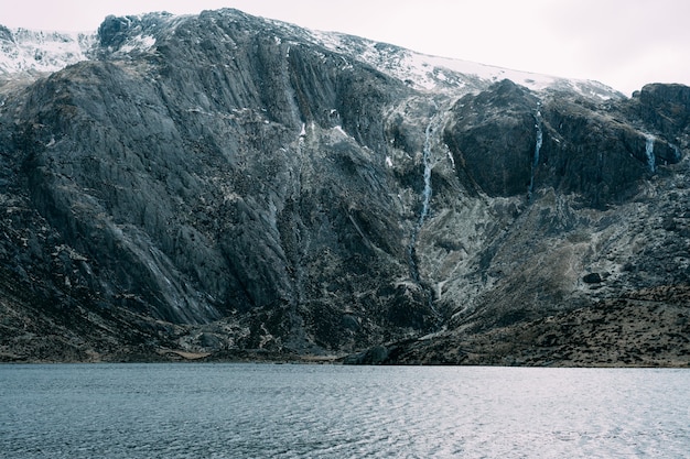 Foto gratuita lago rodeado de montañas cubiertas de nieve.