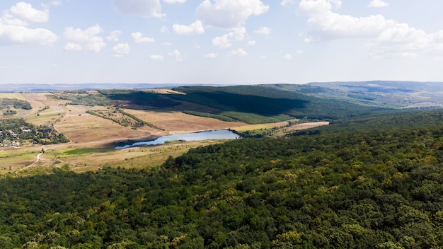 Lago ubicado en las tierras bajas, bosque en primer plano y colinas