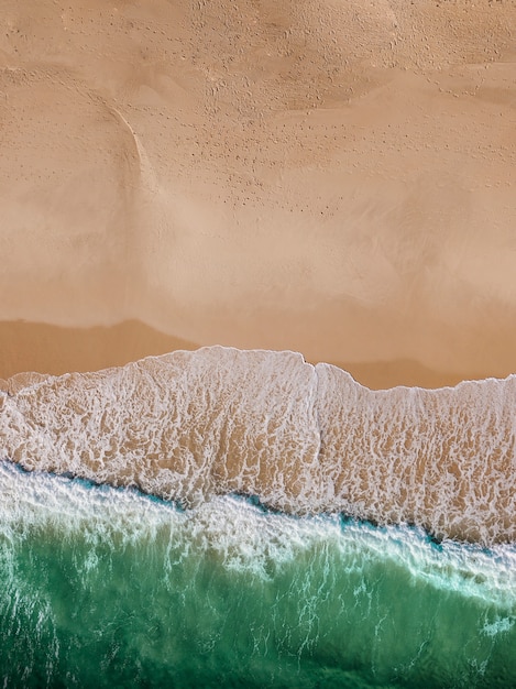 Laguna con olas de mar y playa de arena.